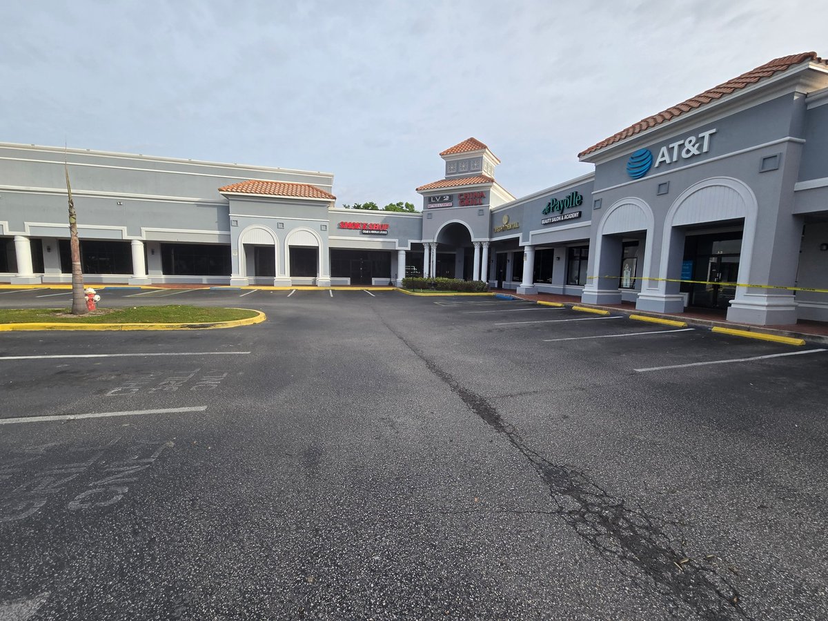 Empty shopping center parking lot with storefronts including AT&T cleaned for the plaza owner