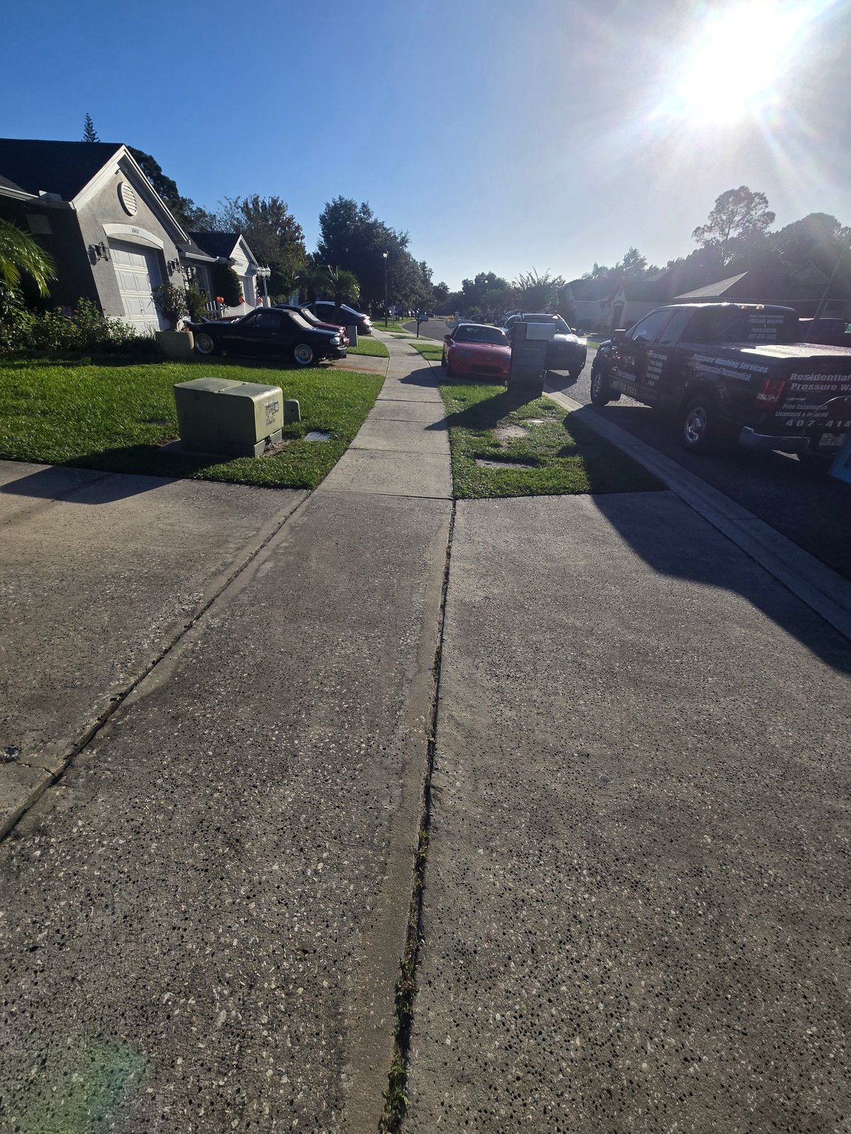 Sunny suburban Central Florida street with a sidewalk in front of a home our crew just washed