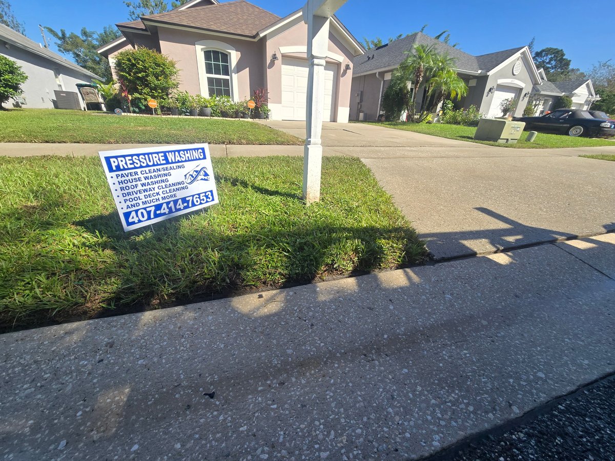 James Gold pressure washing yard sign on the lawn in front of a residential home with a clean driveway
